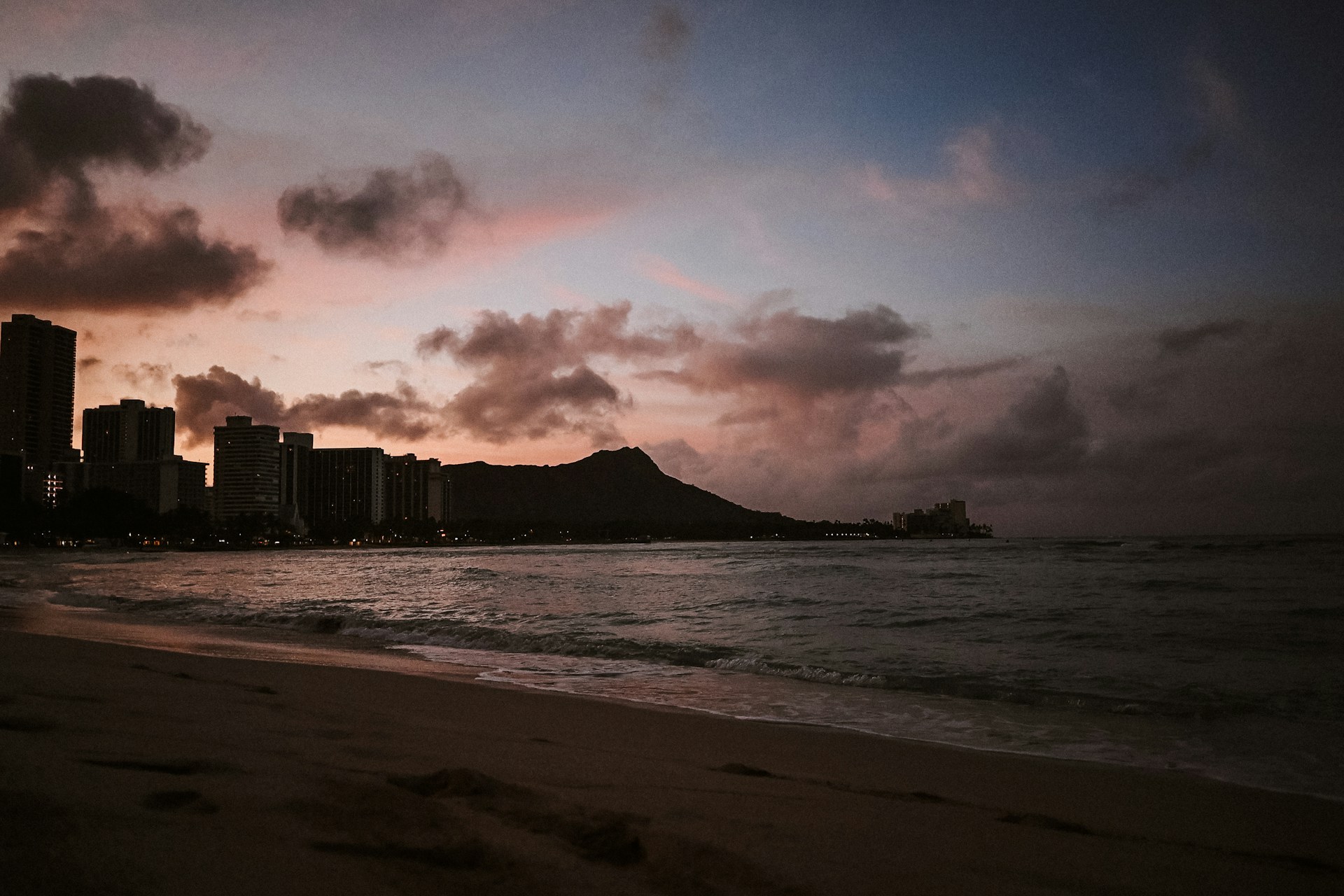 Sunset on Waikiki Beach. Diamond head and buildings in the background with the beach on ocean in the foreground