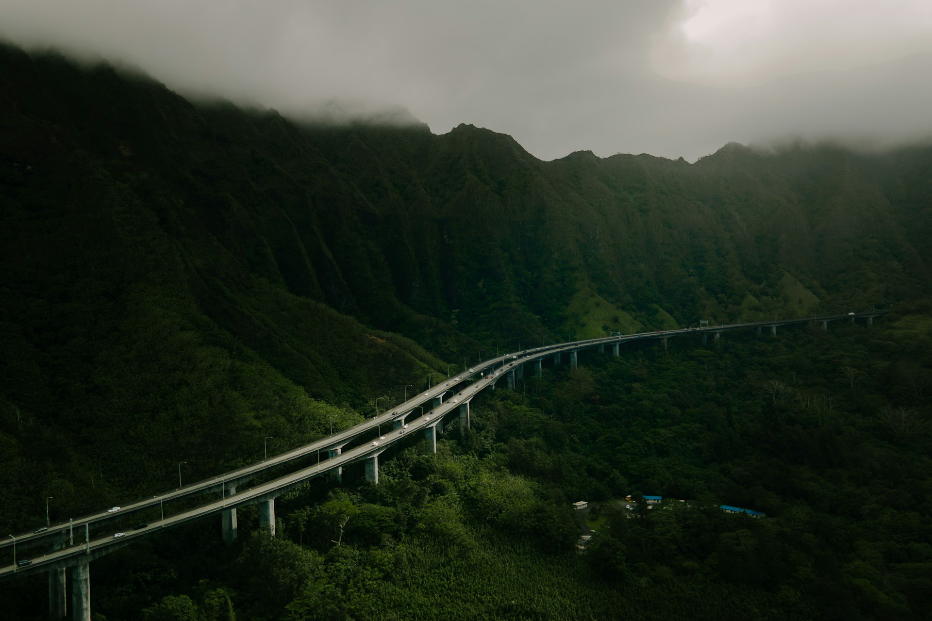 Oahu lush green mountain range with birdseye view of a freeway system